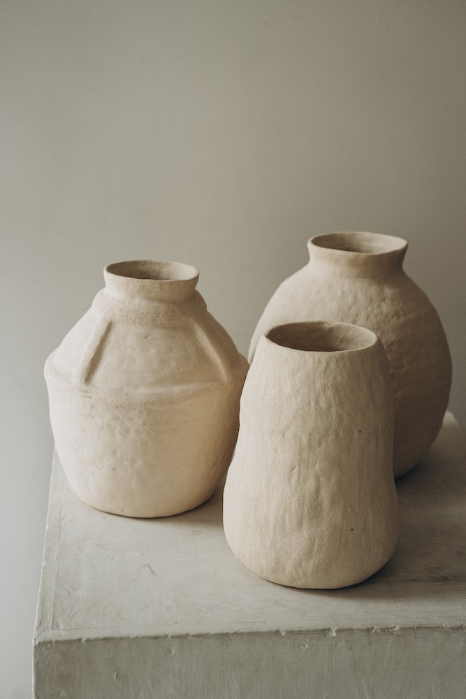 3 white ceramic jars on white table